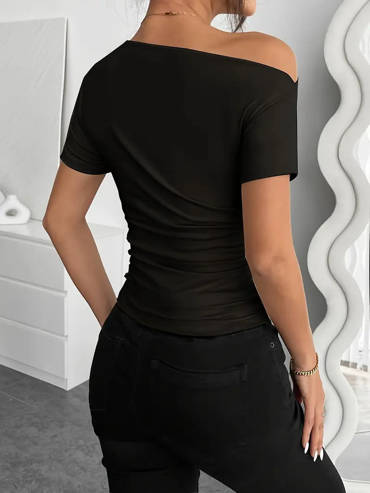 Short top with short sleeves, featuring irregular pleating and a slim-fit cut