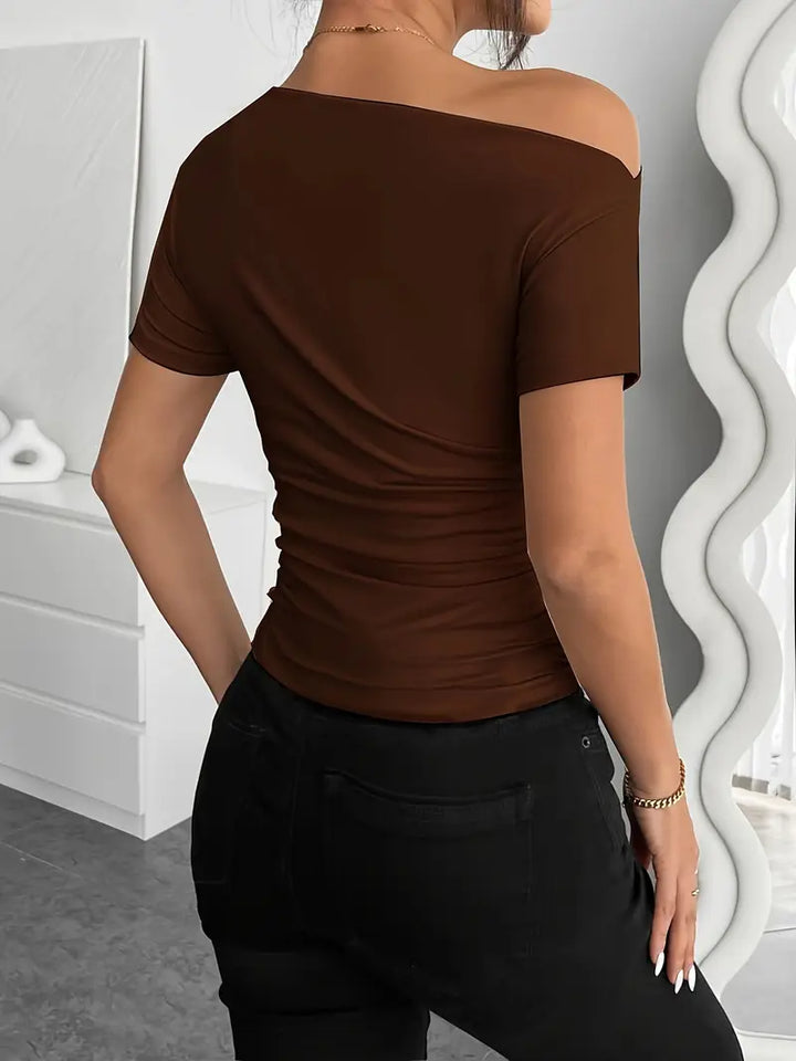 Short top with short sleeves, featuring irregular pleating and a slim-fit cut